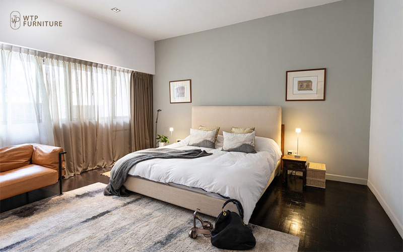 A cozy queen size bed paired with furnitures of earthy tones, and a minimalistic carpet