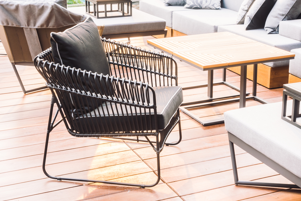 Outdoor hardwood chair and table with cushions.